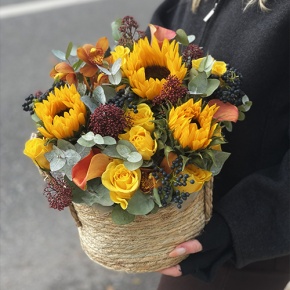 Композиция в сумке "Тональность" из подсолнухов, калл, ягод вибирнума, лимонных роз, скиммии и орхидеи в Кубинке